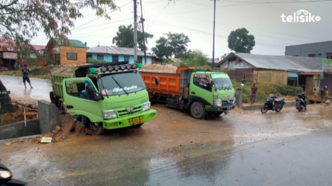 Hujan Deras, Ban Mobil Truk Tertahan Tanah di Jalan Rusak