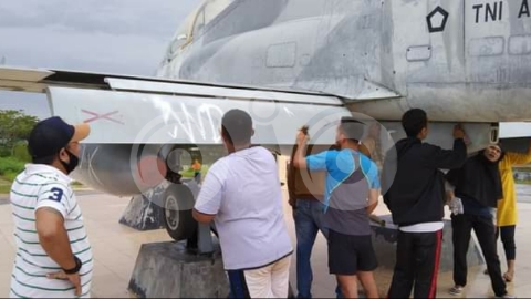 Pol PP Muna Bersihkan Coretan di Tugu Pesawat Tempur
