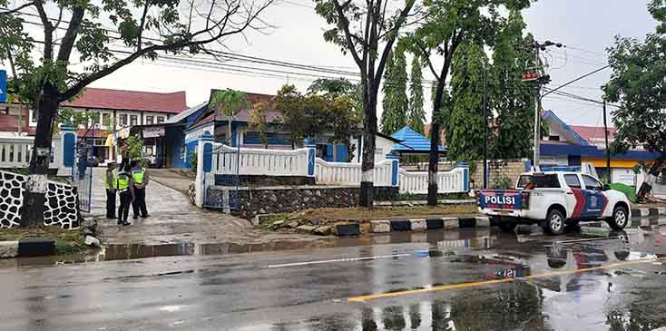 Polisi berjaga di sekitar lokasi rekonstruksi penembakan mahasiswa UHO Randi, di Kantor Dinas Tenaga Kerja dan Transmigrasi Sult