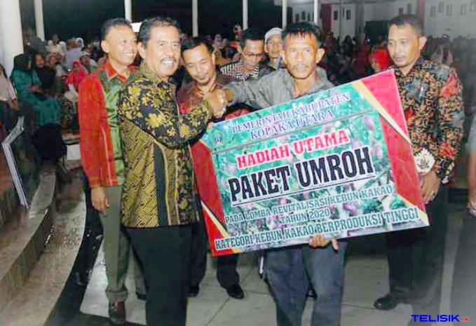 Bupati Kolaka Utara, Nur Rahman Umar saat menyerahkan hadiah paket umrah kepada petani. Foto: Muh. Risal/Telisik