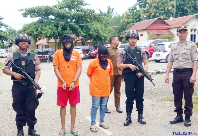 Dua tersangka pengedar dan pengguna Sabu digiring ke ruang media Center Humas Polres Baubau.  Foto: Ridwan Amsyah/Telisik