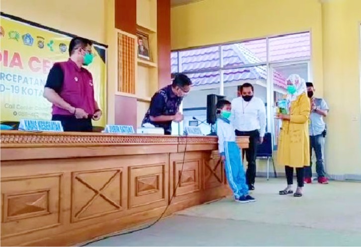 Bocah Kelas 1 SD Ananda, saat menyerahkan isi tabungannya kepada Wali Kota Kendari. Foto: Ist.
