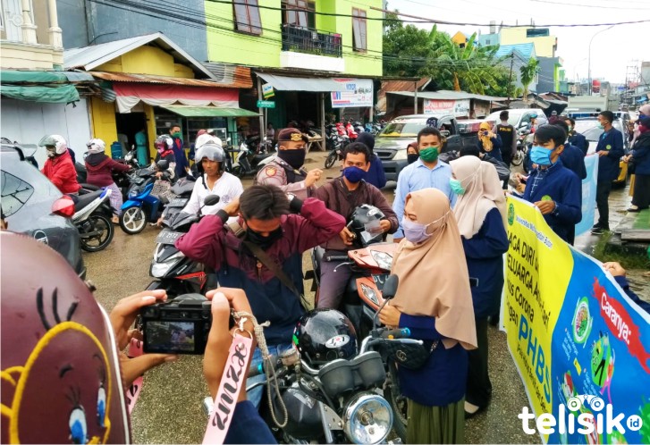 Mahasiswa PBSI UM.Buton Bersama  bersama Kepolisian Resort Baubau mebagikan masker kepada pengguna jalanan, Foto: Ridwan Amsyah/Telisik