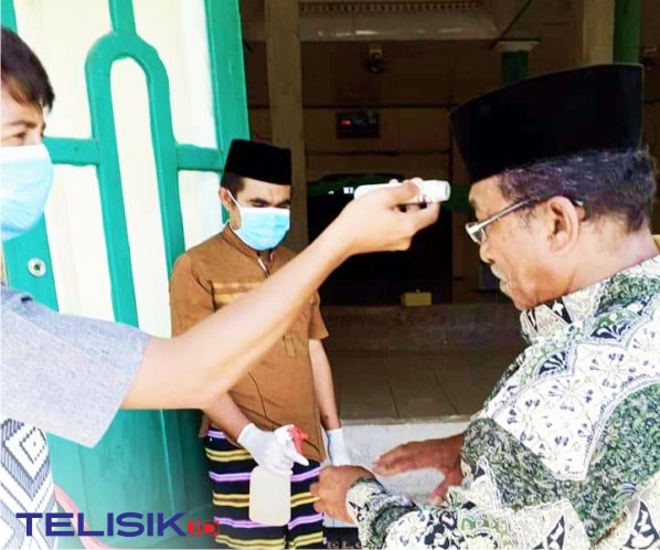 Melakukan cek suhu tubuh bagi warga desa setelah sholat. Foto: Muhammad Israjab/Telisik