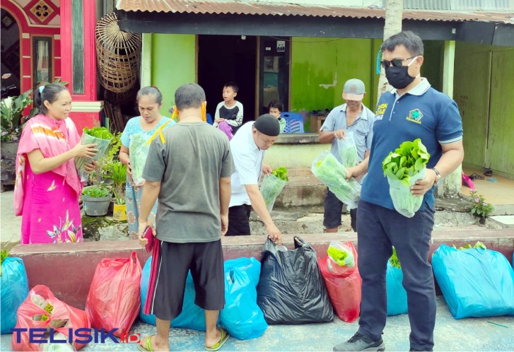 Anggota DPRD Kota Kendari, Sahabuddin, memberikan bantuan sayuran hidroponik kepada masyarakat. Foto: Musdar/Telisik