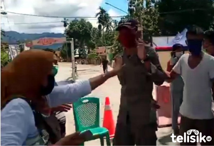 Seorang ibu bersitegang dengan petugas penjaga perbatasan Konut  Foto: Dul/Telisik