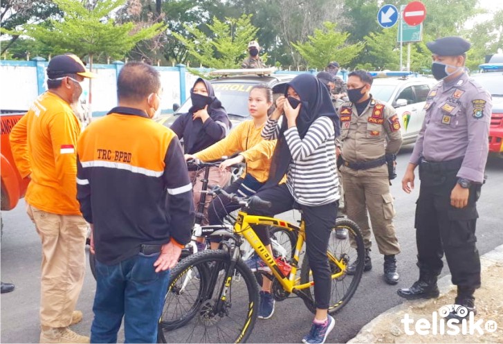 Petugas menghentikan warga yang tidak menggunakan masker saat di luar rumah Foto: Yus/Telisik