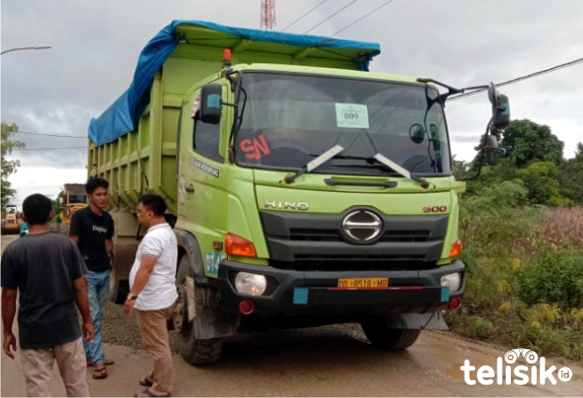 Kendaraan sepuluh roda milik PT. Jhonlin saat ditahan warga di Desa Lombakasi. Foto: Hir/Telisik