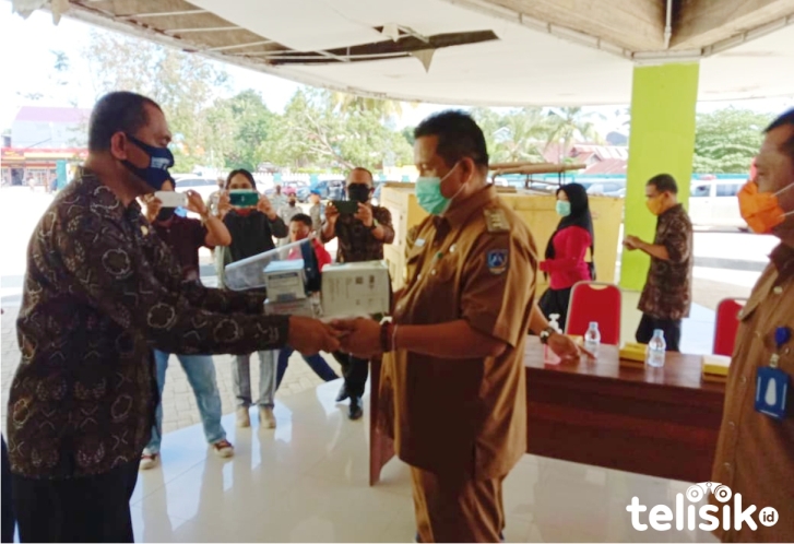Ketua Kagama Muna, Syahrir menyerahkan APD ke Bupati Muna, LM Rusman Emba. Foto: Sunaryo/Telisik
