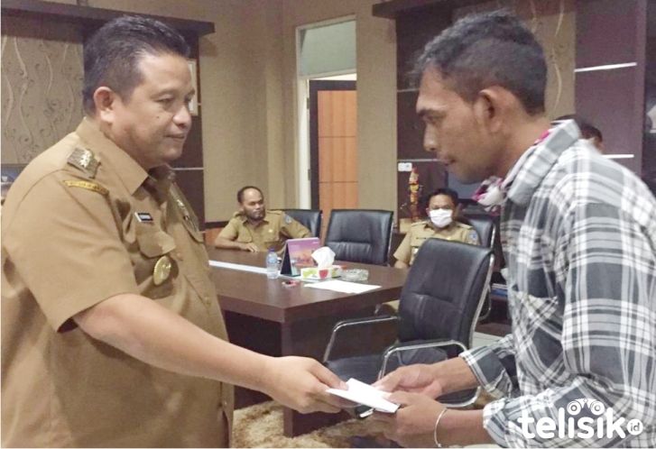 Bupati Muna, LM Rusman Emba menyerahkan bantuan pada La Jakiri, ayah Aidan. Foto: Sunaryo/Telisik