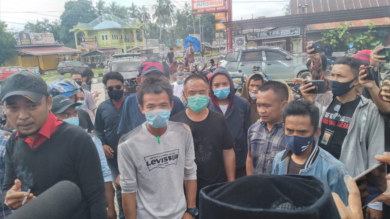 Mr. Wey (tengah, baju hitam) bersama juru bicaranya, Hendrik, saat diciduk demonstran. Foto: Ibnu Sina Ali Hakim/Telisik