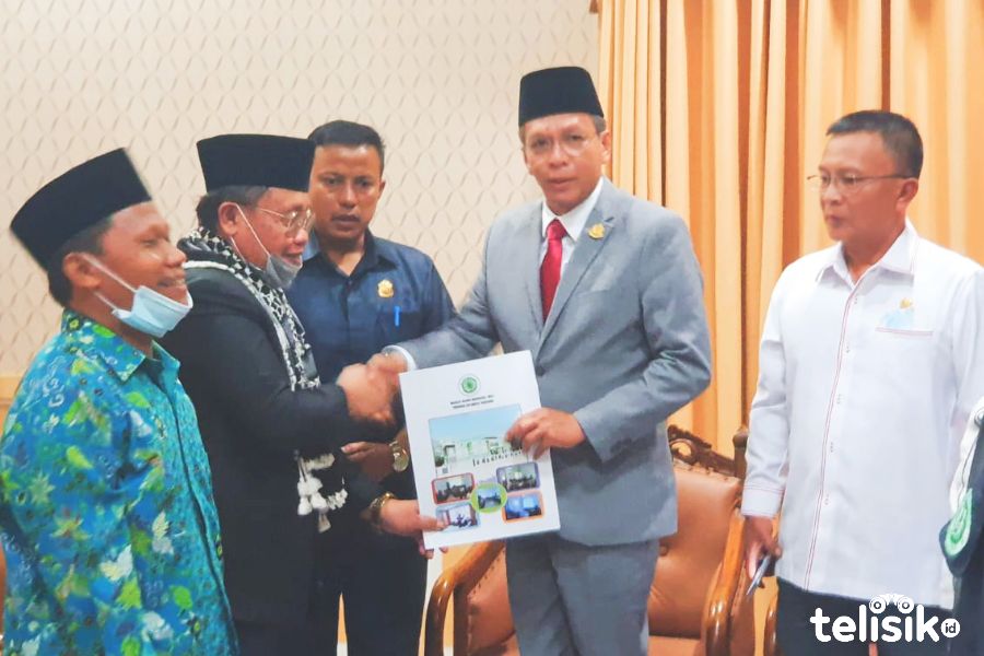 Ketua Umum MUI Sultra, Drs. KH Mursyidin M.HI (kedua dari kiri) saat menyerahkan pernyataan sikap kepada Ketua DPRD Sultra, Abdurrahman Shaleh (tengah). Foto: Nasir/Telisik