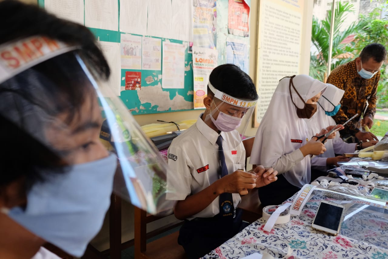 Siswa membuat pelindung wajah (face shield) dengan dibantu guru di halaman SMP Negeri 13 Solo, Jawa Tengah. Foto: Repro Antara