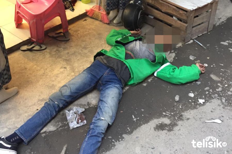 Sopir ojol terlihat terbaring di depan toko di lampu merah Aksara Medan. Foto: Ones Lawolo/Telisik