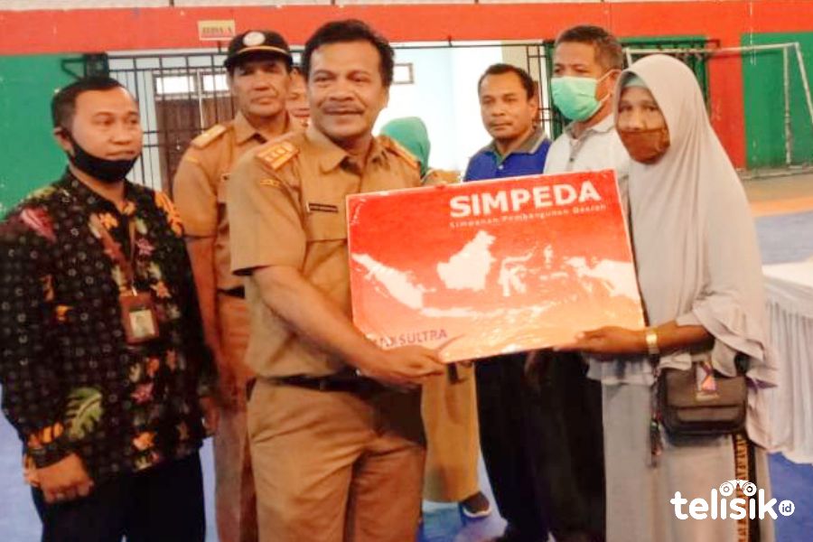 Kadis Perindag, La Ode Darmansyah menyerahkan bantuan pada pedagang korban kebakaran. Foto: Sunaryo/Telisik