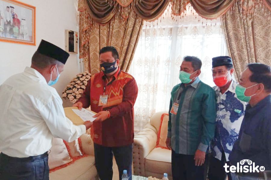 Sekretaris KPU Muna, Halisi menyerahkan PKPU 13 pada Balon Bupati Muna, LM Rusman Emba. Foto: Sunaryo/Telisik