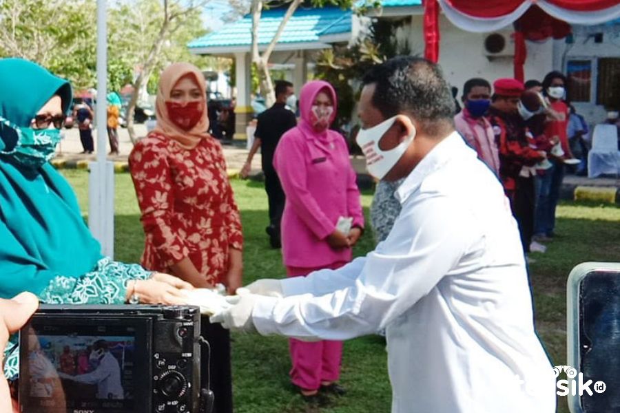 Ketua KPU Wakatobi, Abdul Rajab membagikan masker sesaat setelah apel  bertajuk "Wakatobi Bermasker". Foto: Mohamad Lukman Saputra/Telisik