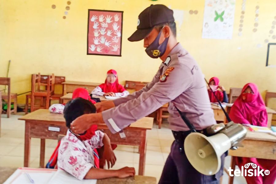 Giat personel kepolisian Polres Bombana saat mengedukasi penggunaan masker pada siswa. Foto: Hir/Telisik