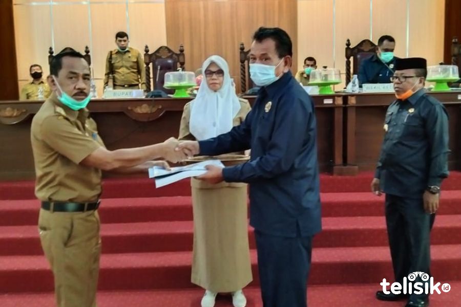 Ketua DPRD Muna, La Saemuna (kanan) menyerahkan dokumen APBD-P pada Asisten III, Ali Basa. Foto: Sunaryo/Telisik