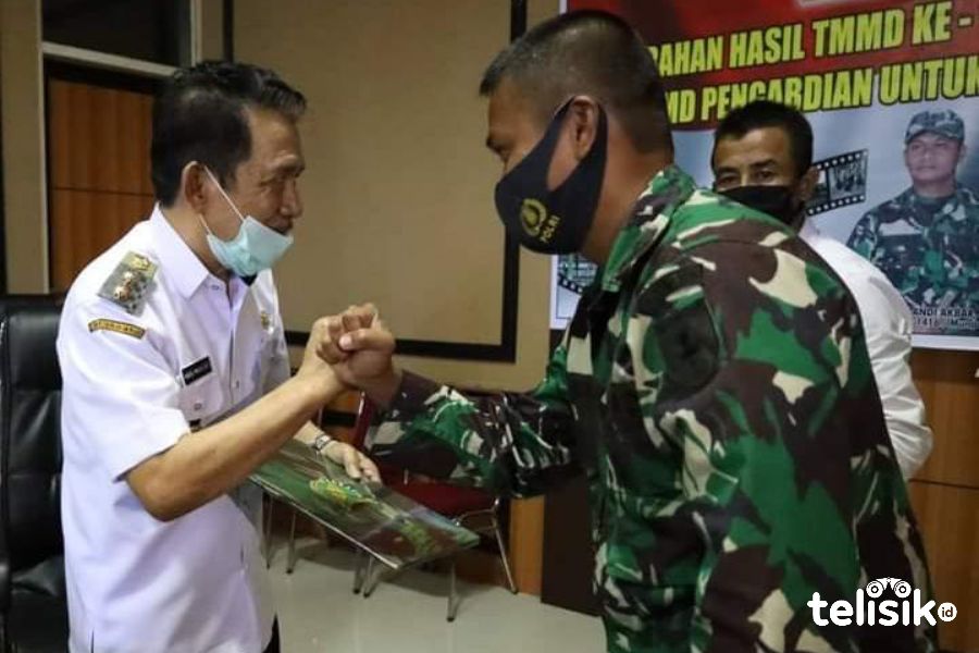 Dandim 1416 Muna, Letkol Arm Andi Akbar menyerahkan naskah hasil kerja TMMD ke Plt Bupati, Abdul Malik Ditu. Foto: Sunaryo/Telisik