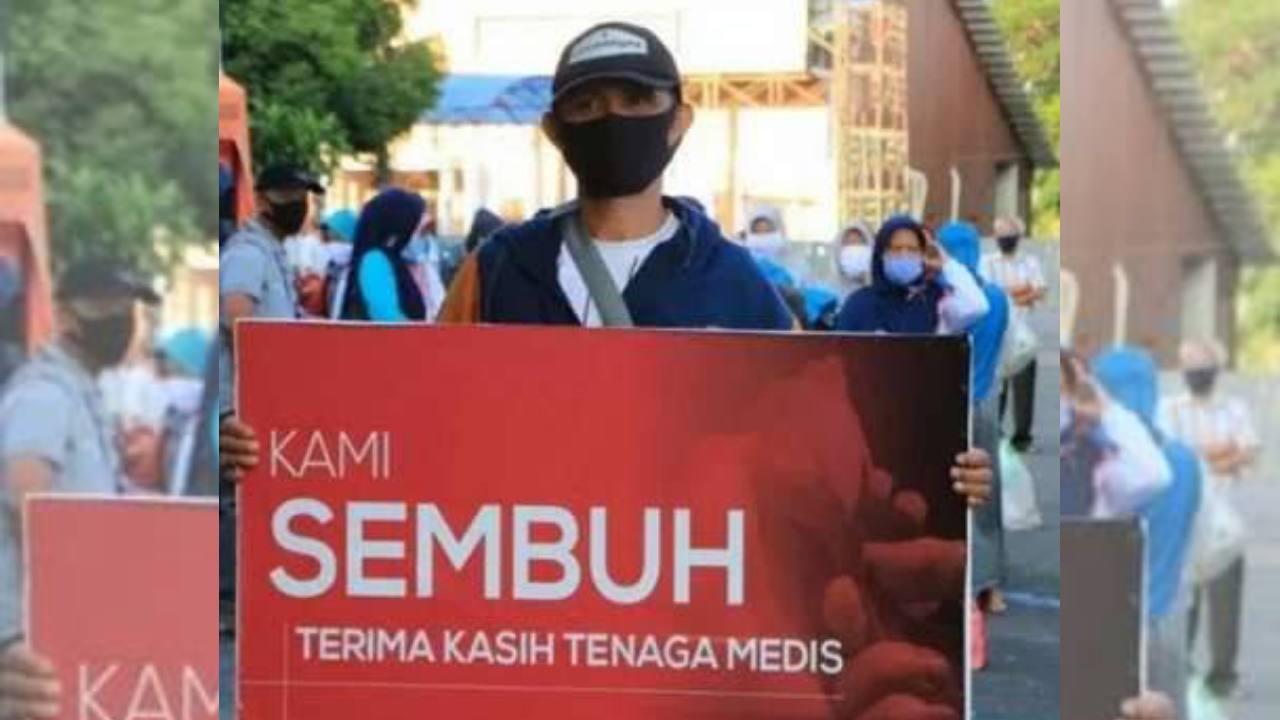 Seorang bentangkan spanduk ucapan terima kasih kepada tenaga medis. Foto: Repro Bisnis.com