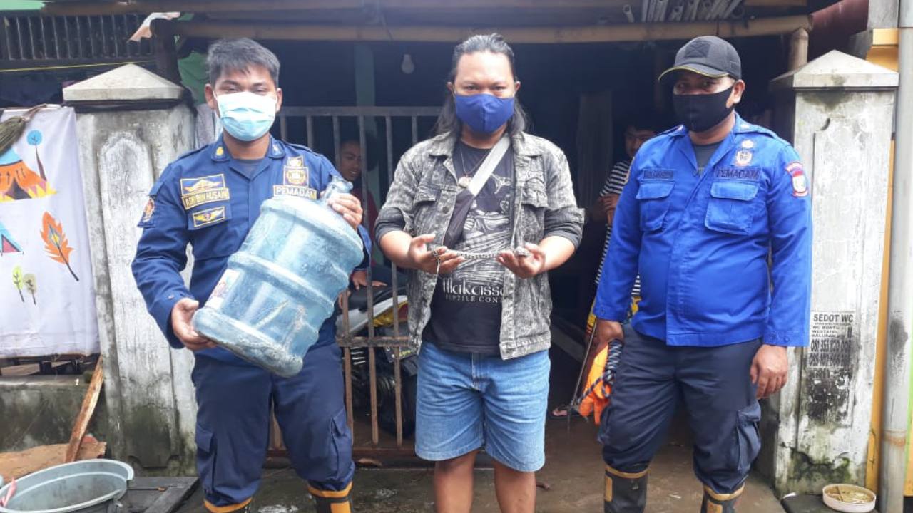 Petugas Damkar Kota Makassar saat mengamankan anak ular piton dari rumah warga. Foto: dok. Damkar