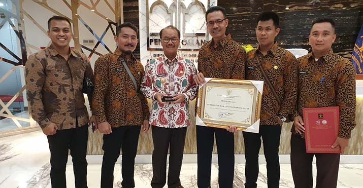 Bupati Konsel, Surunudin Dangga saat menunjukkan penghargaan yang diberikan oleh Kemenkumham sebagai daerah Peduli HAM pada tahun 2017. Foto: Ist.