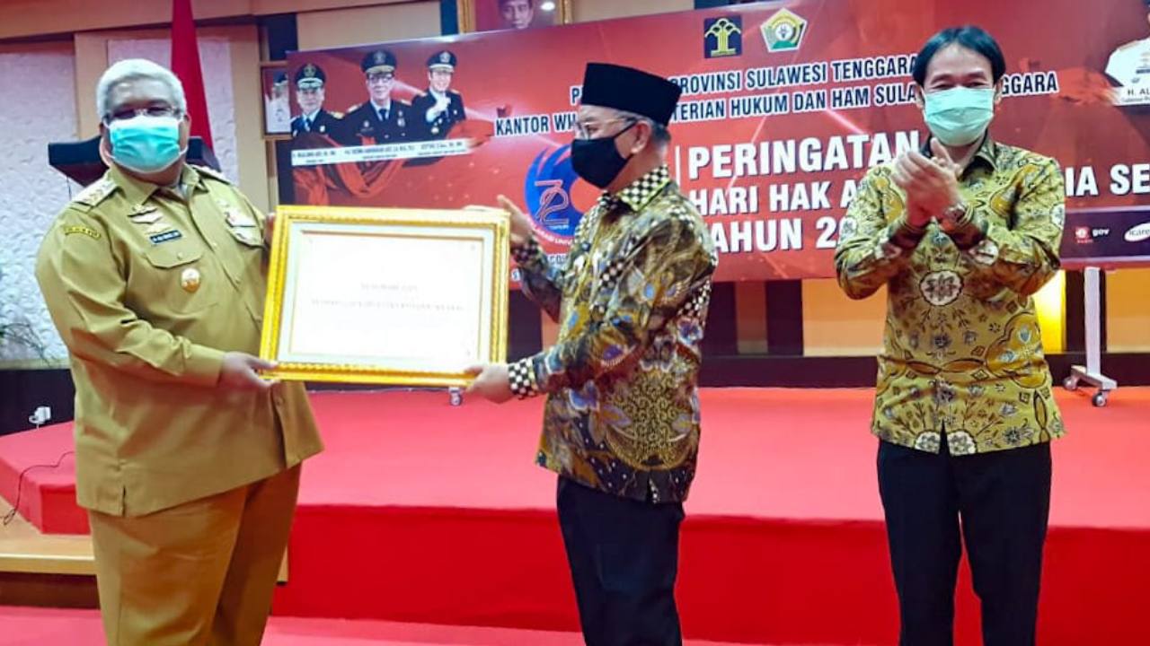 Bupati Konsel, Surunuddin Dangga saat menerima plakat penghargaan daerah peduli HAM. Foto: Ist.