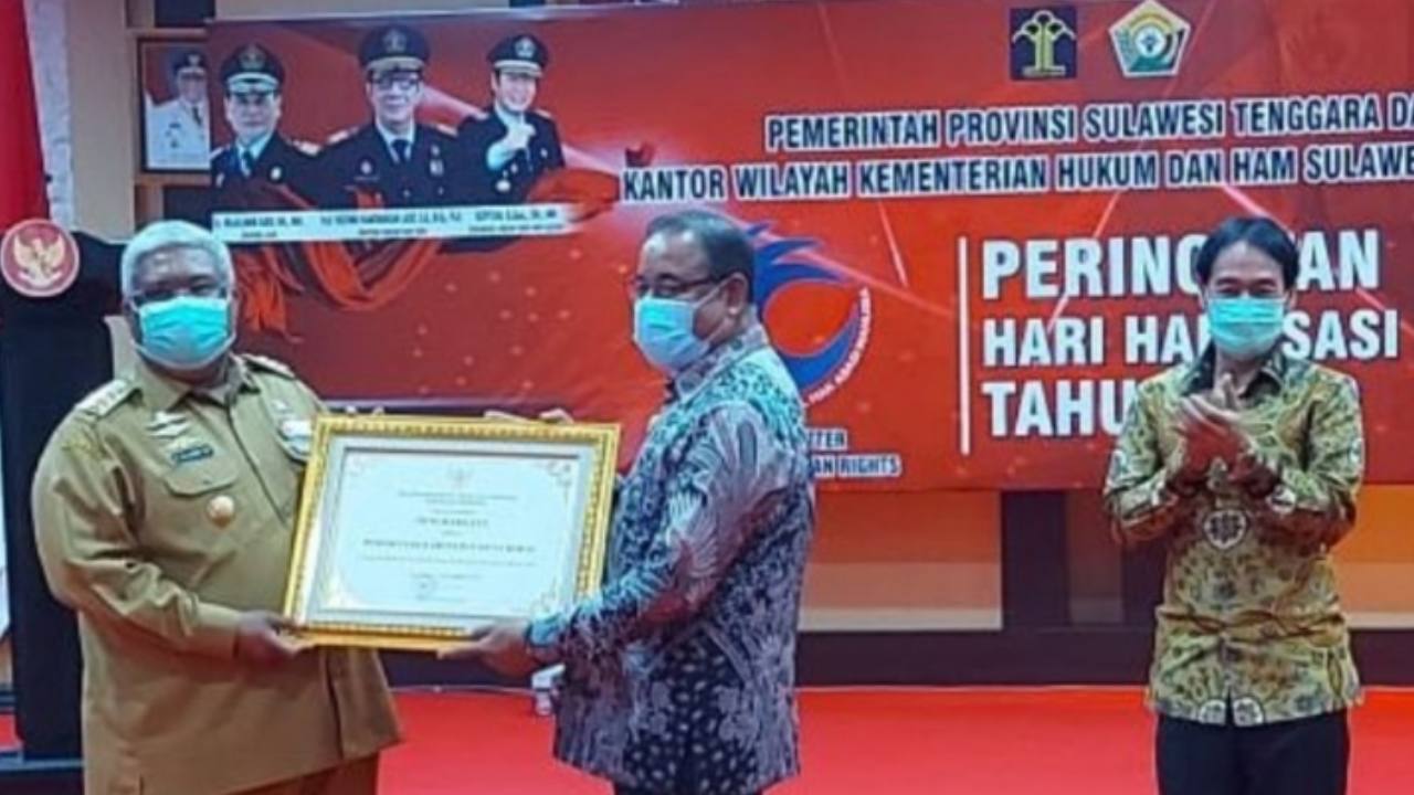 Penyerahan Plakat Hari HAM Sedunia oleh Gubernur Sulawesi Tenggara, Ali Mazi yang diterima langsung oleh Plt. Bupati Muna Barat, Achmad Lamani. Foto: Ist.