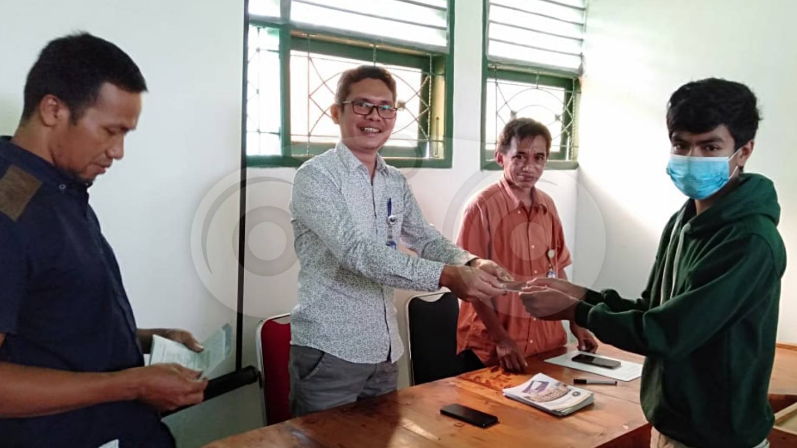 Ketua STIP Wuna, Rochmady menyerahkan buku rekening pada mahasiswa. Foto: Sunaryo/Telisik