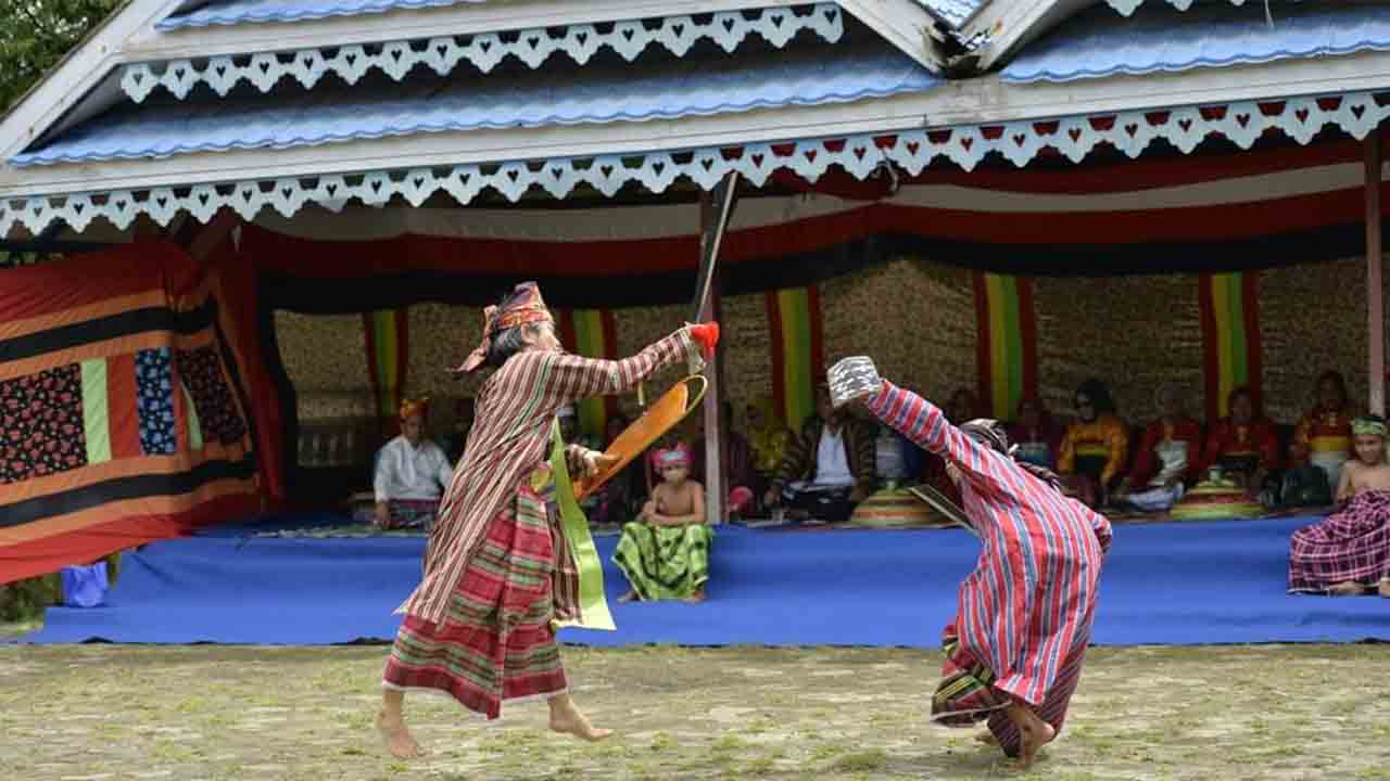 Parodi peperangan yang dilakoni masyarakat. Terlihat mereka saling serang. Foto: Ist.
