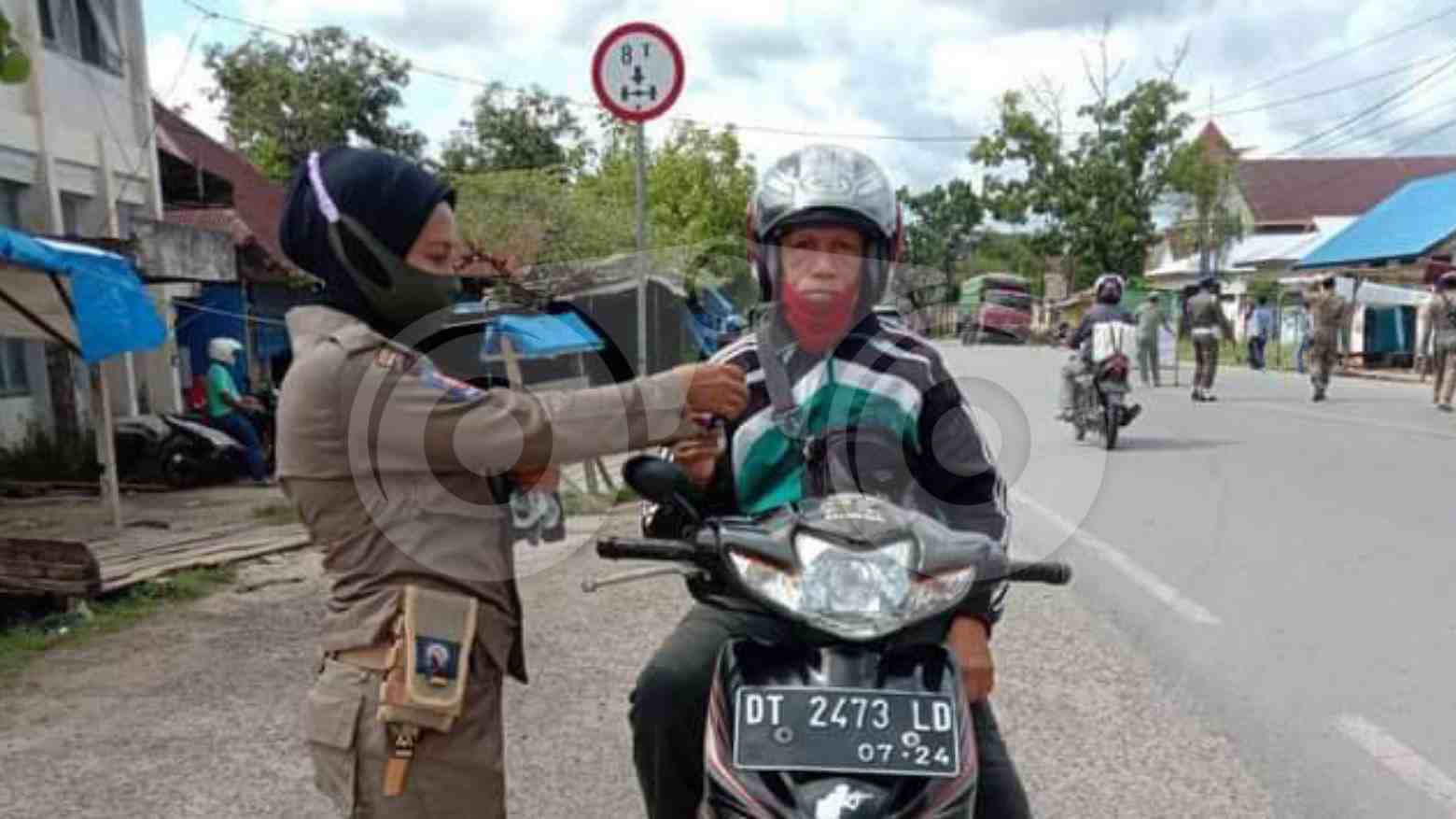 Personil Sat Pol PP membagikan masker pada masyarakat. Foto: Sunaryo/Telisik