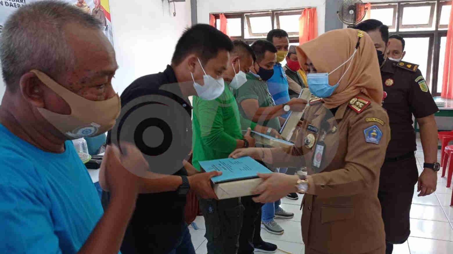 Kepala Bapenda Kota Kendari Sri Yusnita (pakaian keki) menyerahkan SPPT pada lurah di Kecamatan Kendari Barat. Foto: Sumarlin/Telisik
