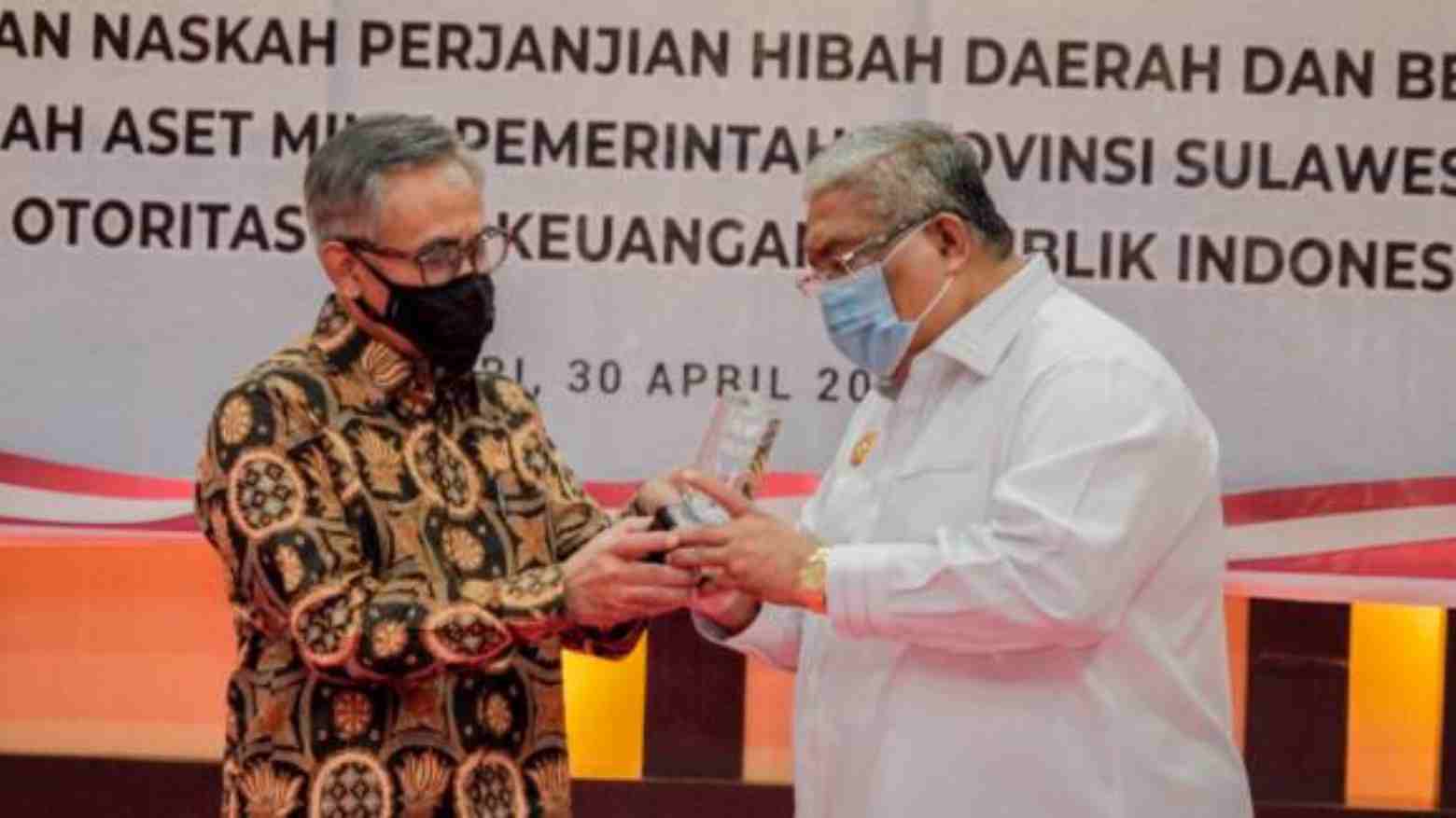 Penyerahan cendramata angara Kepala OJK Sultra dan Gubenur Sultra, Ali Mazi. Foto: Repro Dinas Kominfo Sultra