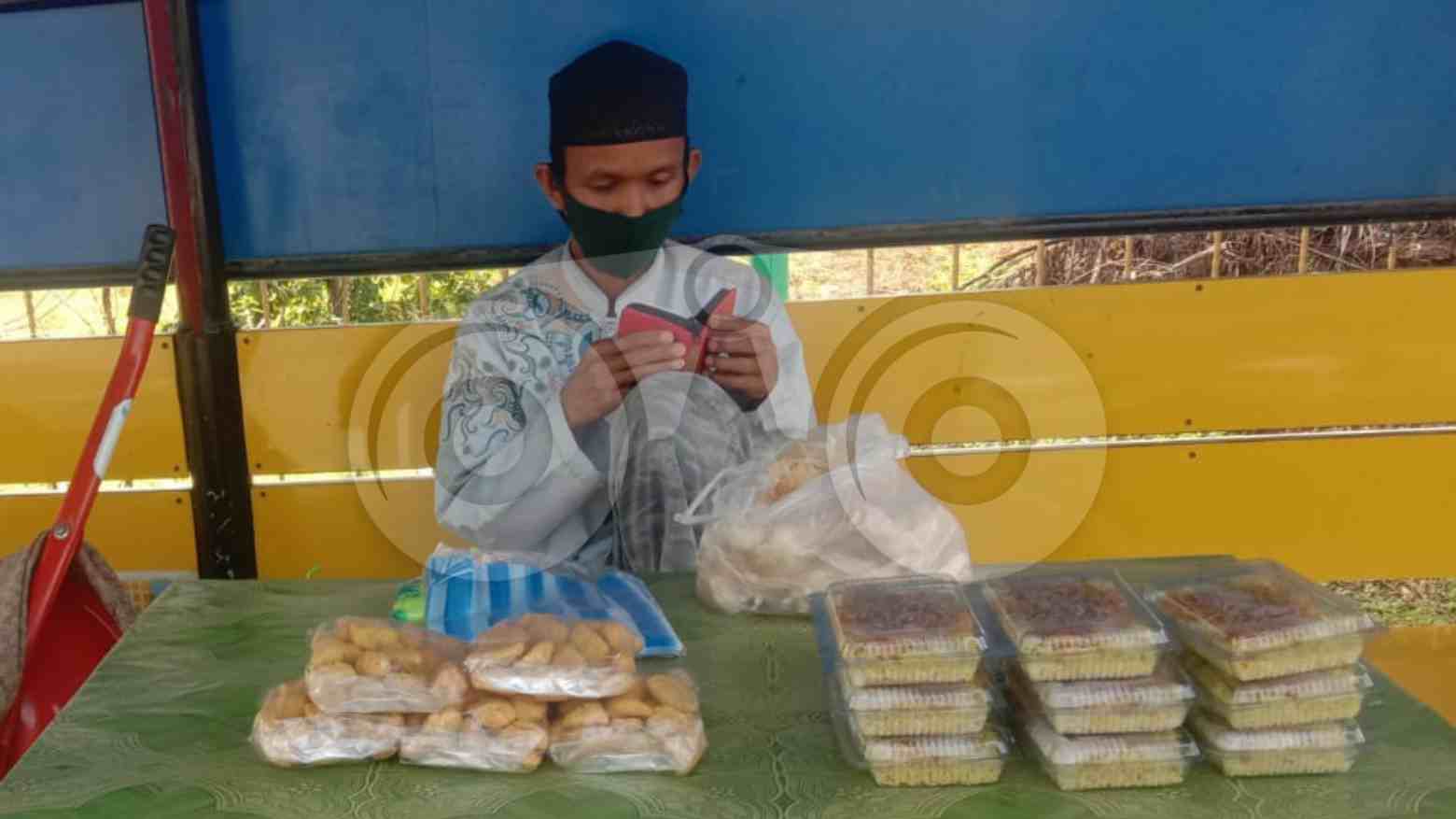 Hadi di sela-sela berjualan nasi kuning mengisi waktu dengan mengaji. Foto: Muh. Sabil/Telisik