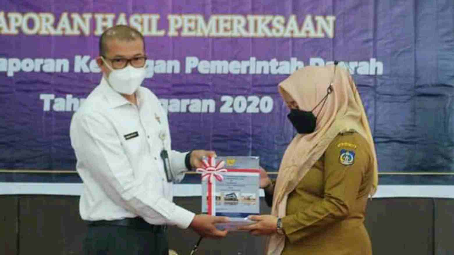 Plt Bupati Koltim, Hj Andi Merya Nur (kanan) saat menerima hasil laporan keuangan Pemda tahun 2020 dari Kepala BPK Perwakilan Sultra. Foto: Ist.