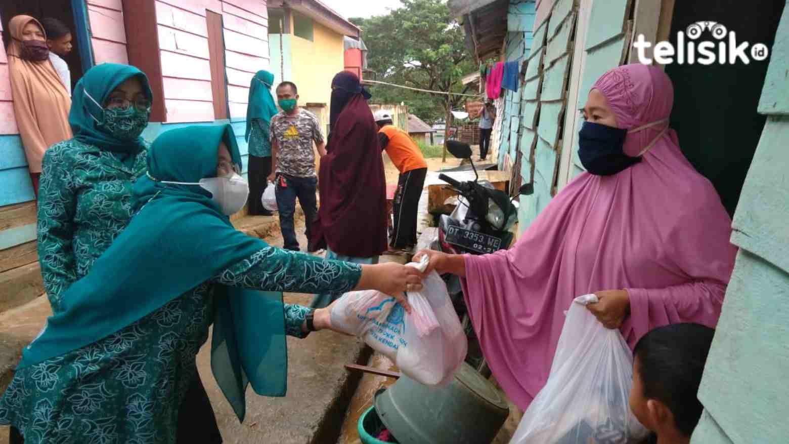 Ketua Penggerak PKK Kendari, Sri Lestari, saat menyerahkan bantuan paket sembako ke warga TPA Puuwatu. Foto: Fitrah Nugraha/Telisik
