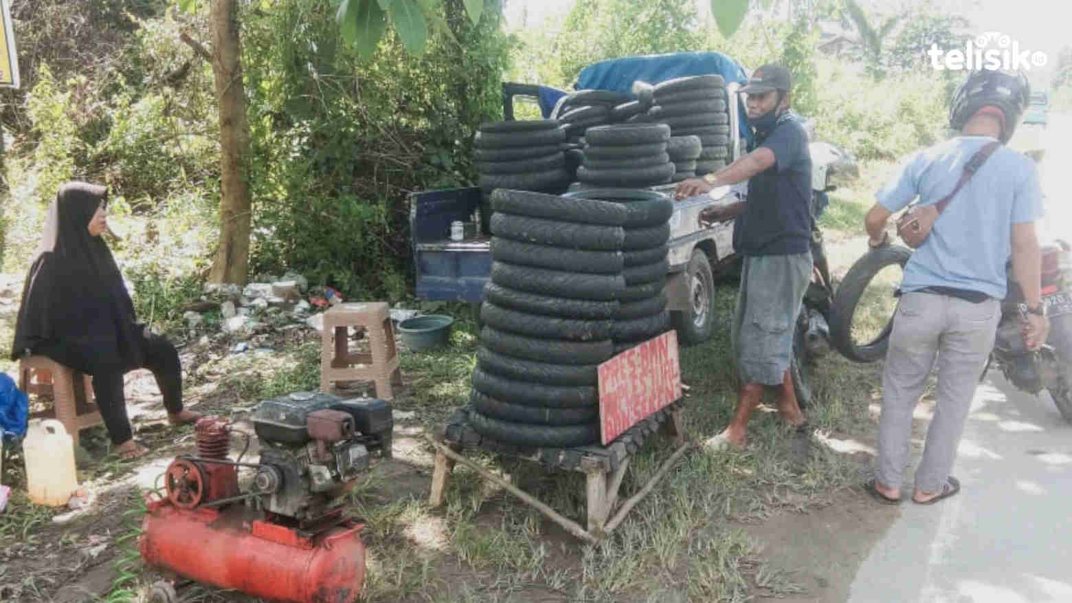 Eron (tengah), pemilik bengkel keliling saat melayani pelanggan. Foto: Kardin/Telisik