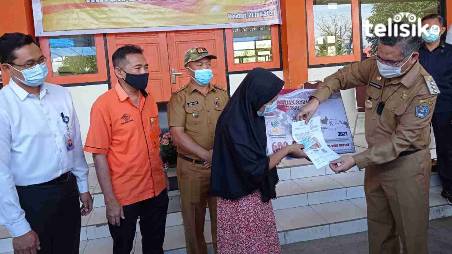 Wali Kota Kendari Sulkarnain Kadir (kanan) menyerahkan Bantuan Sosial Tunai pada perwakilan warga Kota Kendari. Foto: Sumarlin/Telisik