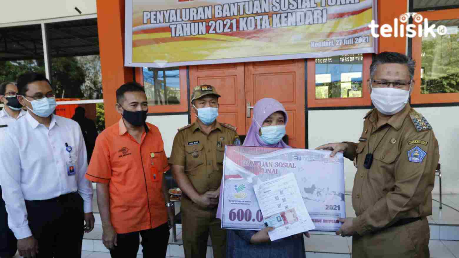 Wali Kota Kendari, Sulkarnain Kadir (kanan). saat menyalurkan dana BST. Foto: Musdar/Telisik