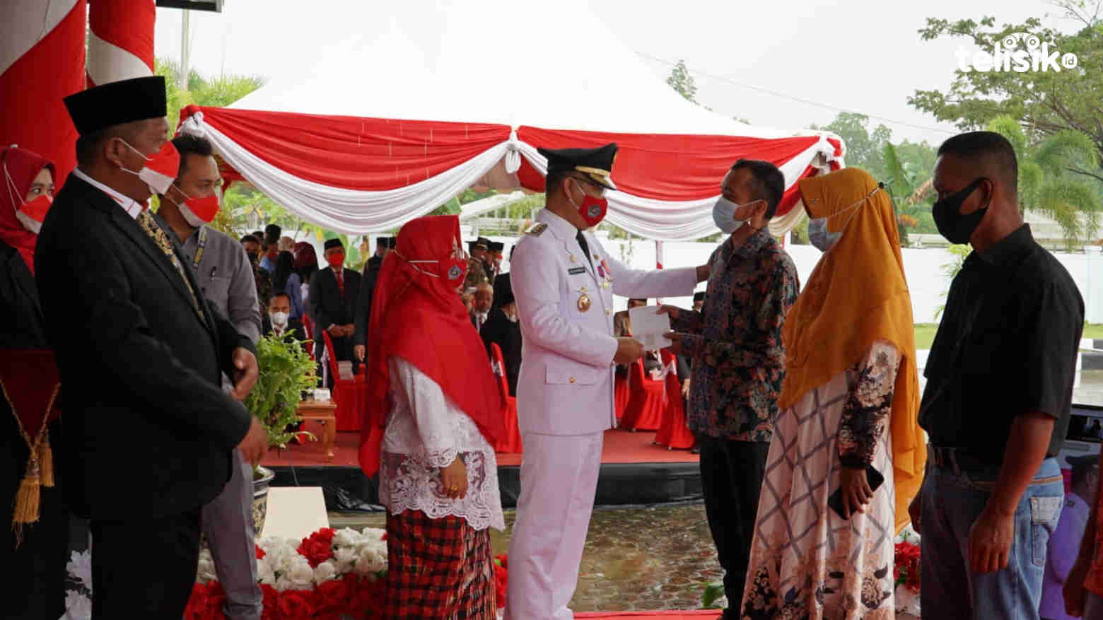 Wali Kota Kendari Sulkarnain Kadir secara simbolis menyerahkan buku tabungan pada pelaku UKM terdampak COVID-19. Foto: Sumarlin/Telisik