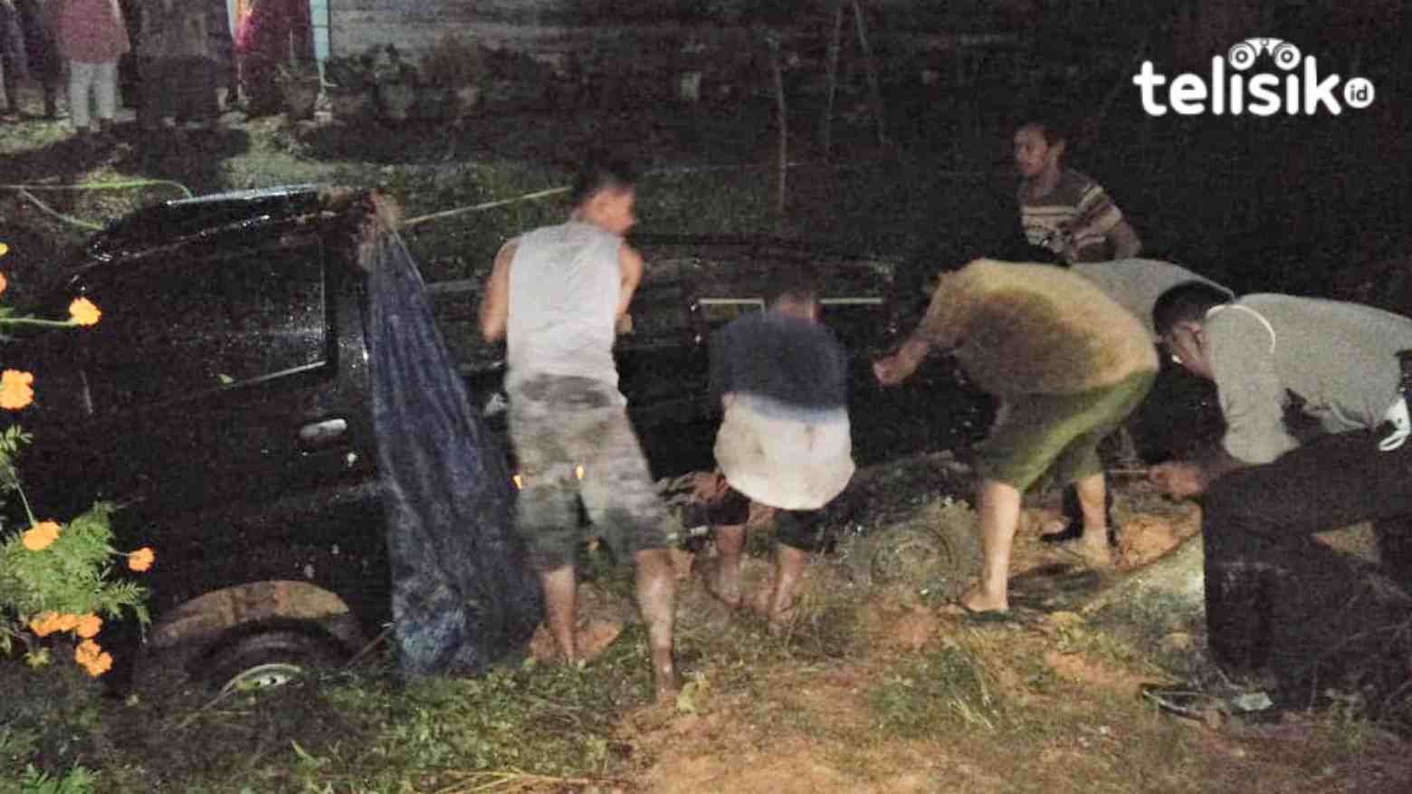 Warga bersama aparat kepolisian berusaha menaikkan mobil pickup yang habis kecelakaan. Foto: Thamrin/Telisik