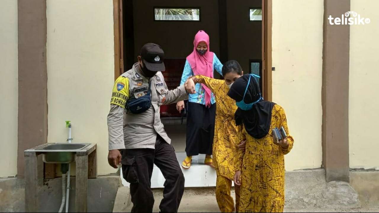 Bhabinkamtibmas Polsek Rumbia Brigadir Fatriyono. C, saat menemani Nurhayati dari lokasi vaksinasi. Foto: Hir/Telisik