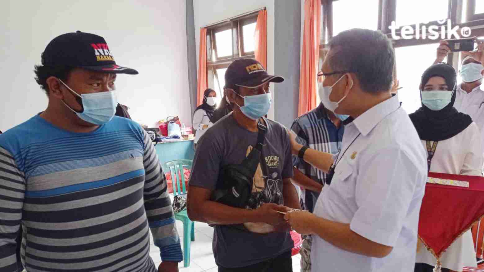 Wali Kota Kendari Sulkarnain menyerahkan bantuan uang tunai Rp 300 ribu pada  Muh. Asta Filar, perwakilan nelayan yang terkena dampak COVID-19. Foto: Sumarlin/Telisik