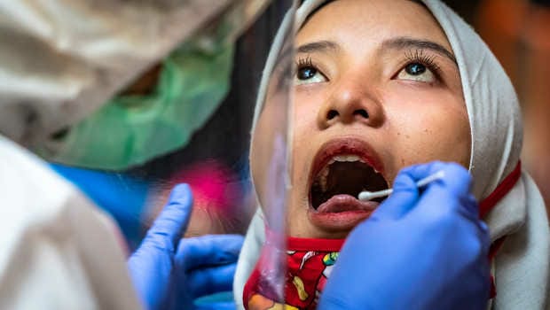 Nakes sedang melakukan Swab Antigen COVID-19 kepada warga. Foto: Repro Beritasatu