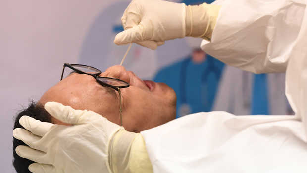 Tenaga kesehatan sedang melakukan pengambilan sampel pada hidung pasien untuk uji COVID-19. Foto: Repro Beritasatu