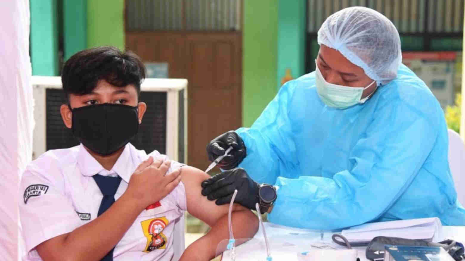 Nakes sedang menyuntik vaksin COVID-19 kepada siswa SMP. Foto: Repro Pikiran Rakyat