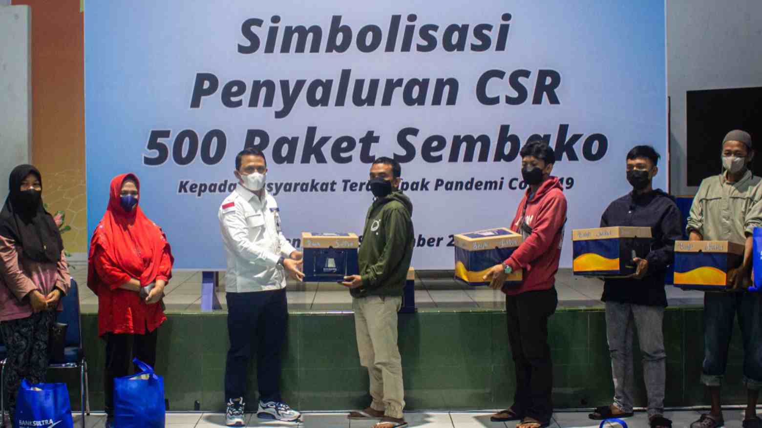 Penyerahan bantuan paket sembako kepada masyarakat oleh Dirut Bank Sultra. Foto: Ist/Humas Bank Sultra