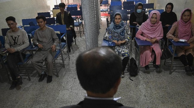 Sekelompok mahasiswa menghadiri kelas di sebuah universitas swasta di Kabul. Laki-laki dan perempuan duduk terpisah dengan dibatasi tirai. Foto: Repro Aamir Qureshi/AFP