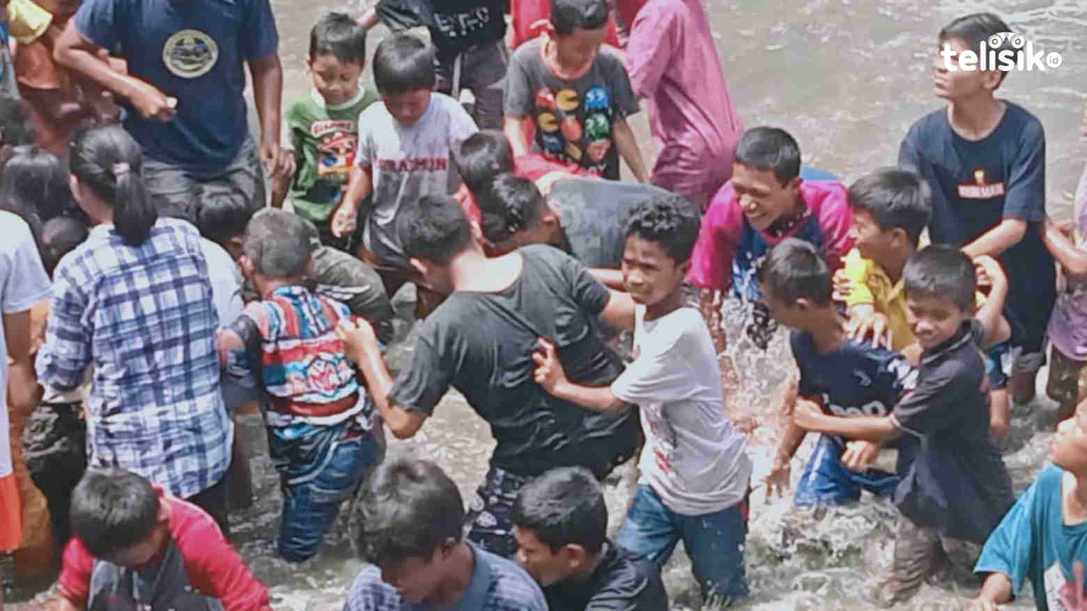Puluhan anak-anak berebut uang dari sesajen  yang dilemparkan oleh peserta ritual adat. Foto: Iradat Kurniawan/Telisik